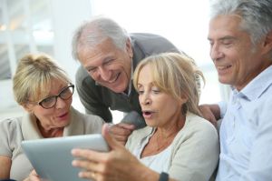 45254346 - group of retired people sitting in sofa and using tablet